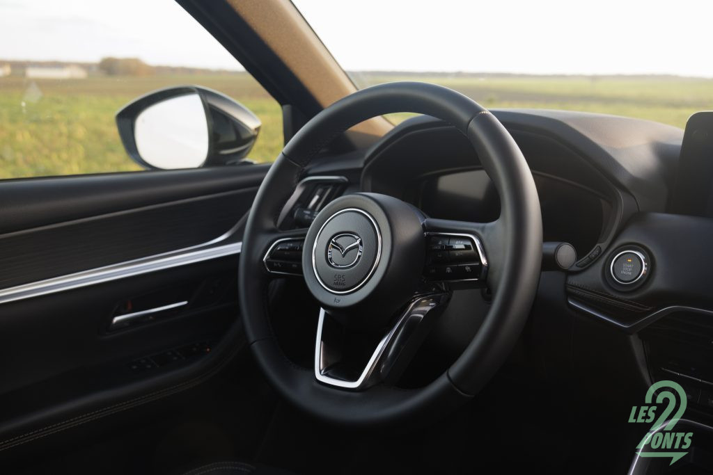 Conforme aux normes GSR-II obligatoires, le Mazda CX-80 propose de couper les avertisseurs sonores d’excès de vitesse grâce à un bouton, à la gauche du volant, devenant rapidement un rituel de passage à chaque démarrage.